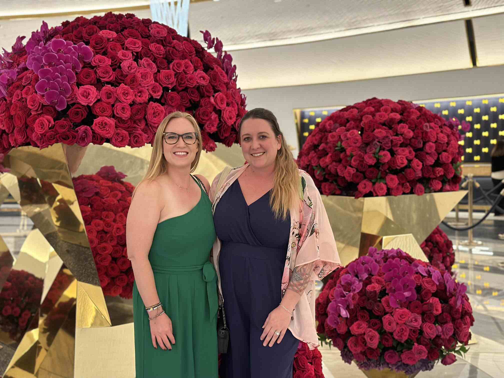 Rebecca Kocsis of Nearmap with TermScout's Kelsey Morton at the Running Legal Like a Business conference in Las Vegas, September 2024, posing in front of rose displays.